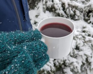 Mittens Hold Elderberry Drink in a Mug