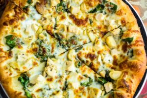 Pizza Topped with Roasted Garlic, Spinach, and Mozzarella Cheese