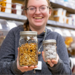 Employee Ari Holding Jars With Bulk Products